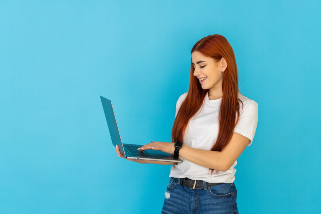 Femme sur un ordinateur devant un fond bleu